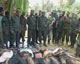 Soldiers stand over LTTE bodies. Image shown on Derana TV, 18 May 2009