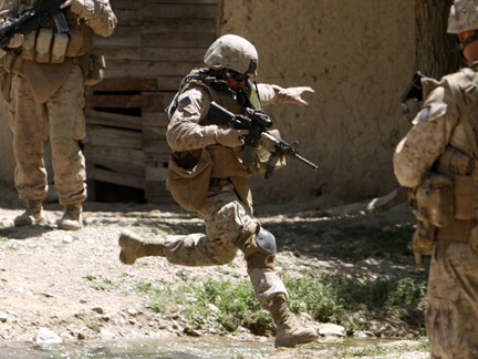 A US Marine jumps over a stream during a patrol in Farah province, Afghanistan, on 5 May 2009 (Photo: Reuters)