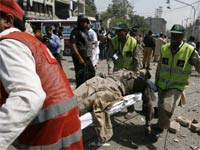 Rescue workers carry the body of a dead policeman at bomb blast site(Credit: Reuters)