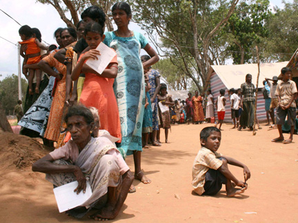 Tamil civilians stand next to their huts in a refugee camp located in northern Sri Lanka (Photo: Reuters)