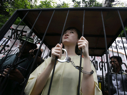 An activist dressed as Aung San Suu Kyi, sits inside a makeshift cell during a protest calling for her release on Monday, outside the Myanmar embassy in Bangkok(Photo: Reuters)