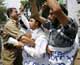 An Indian police officer holds back activists from the separatist Jammu and Kashmir People's Freedom League, during a protest in Srinaga, 11 June 2009.(Photo: Reuters/Fayaz Kabli)