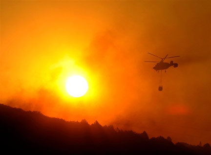 A helicopter drops water on a wildfire burning near Aliaga in Spain(Photo: AFP)