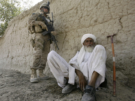 A US marine stands guard next to an Afghan elder in Afghanistan's lower Helmand River Valley.(Photo: Reuters)