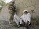 A US marine stands guard next to an Afghan elder in Afghanistan's lower Helmand River Valley.(Photo: Reuters)