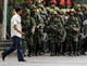 An ethnic Uighur man walks in front of Chinese paramilitary police in Urumqi(Photo:Reuters)
