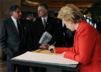 Hillary Clinton signs the memorial book commemorating the Mumbai attacks(Photo: Reuters)