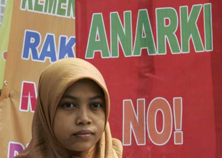 A protester stands in front of a poster during a demonstration against the election results in Jakarta, 25 July, 2009(Photo: Reuters/Dadang Tri)