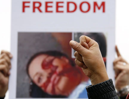Demonstrators hold a placard of Neda Agha-Soltan, a woman who was killed during post-election protests in Iran(Photo: Reuters/Christian Hartmann)