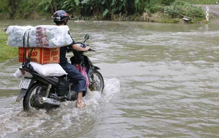 A man drives his motorcycle through a flooded road in Pac Nam district, in Vietnam's northern Bac Kan province(Photo: Reuters)