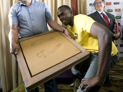 Olympic champion Usain Bolt of Jamaica poses next to his footprints in Paris on Wednesday(Photo: Reuters)