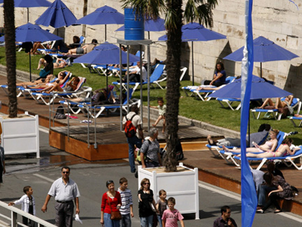 People enjoy the sun as <em>Paris Plages</em> (Paris Beaches) opens along banks of the River Seine in Paris on Monday. (Photo: Reuters)