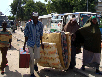 Residents carry their belongings Monday as they leave an area of renewed clashes in Mogadishu.(Photo: Reuters)