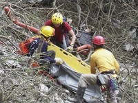 Rescuers transport wrapped bodies from the crash scene of a helicopter Pingtung County.(Photo: Reuters)