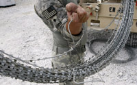 A US soldier carries concertina wire in Kunar province(Photo: Reuters)