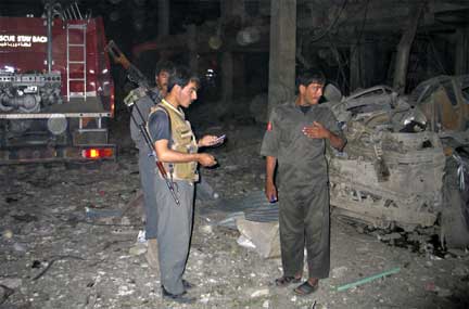Security officials at the site of the bomb blast in Kandahar, 25 August 2009(Photo: Reuters)