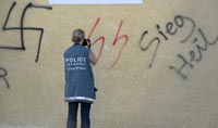 A French policewoman inspects the graffitti on a Muslim religious centre in Toul, eastern France, 19 August, 2009.(Photo: Reuters)