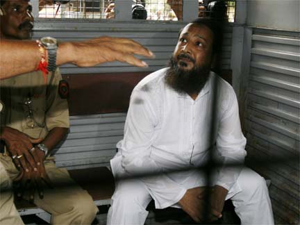Mohammad Haneef Sayyed sits in a police van on his way to the court in Mumbai.(Photo : Reuters)