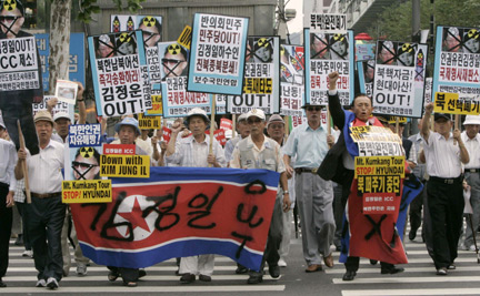 Anti-North Korea protesters hold a defaced North Korean flag during a protest in Seoul on 26 August, 2009. Despite the protest, relations between the two countries have improved in recent weeks(Photo: Reuters)