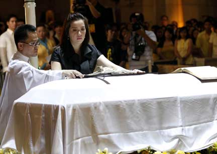 Kris Aquino, daughter of the late former Philippine President Corazon Aquino, places a cross on the casket during the requiem mass at her mother's funeral at Manila Cathedral(Photo: Reuters)