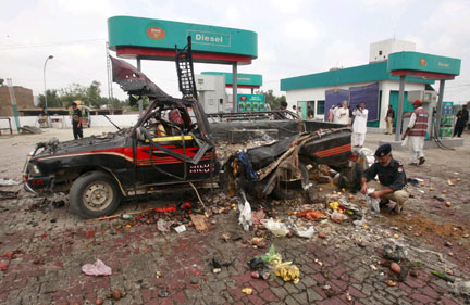 A policeman examines a vehicle at the site of an explosion in Charssada, 160 km from Pakistan's capital Islamabad, on 17 August, 2009. Six people were killed in the attack, which the Taliban claimed responsibility for.(Photo: Reuters/Ali Imam)