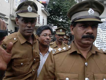 J.S. Tissanayagam is escorted by prison officials out of the Colombo High Court.(Photo: Reuters)