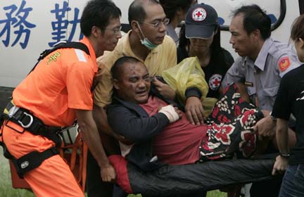 Rescuers carry a man in Chishan, Kaohsiung county, after he was evacuated from a village in southern Taiwan on 11 August, 2009. The village was hit by a landslide, which was caused by typhoon Morakot(Photo: Reuters/Pichi Chuang)