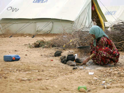 A woman displaced by the ongoing hostilities in northwestern Yemen cooks outside her tent in al-Mazraq refugee camp near the Saada province.(Photo: Reuters)