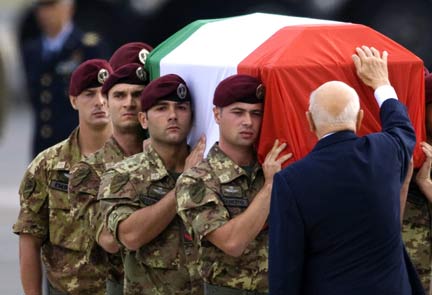 Italy's President Giorgio Napolitano touches the coffin of a soldier at Ciampino airport in Rome (Photo: Reuters)