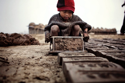 Seven in the morning. Yadhu, 4, concentrates on making bricks with moulds.(Credit: Luca Catalano-Gonzaga)