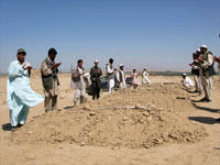 Afghan villagers pray over the graves of their relatives who died in Friday's air strike(Photo: Reuters)