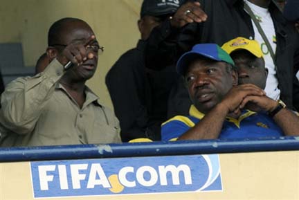 Gabon's newly elected President Ali Bongo (R) listens to Gabon Prime Minister Paul Boyoghe Mba (L) during the Cameroon - Gabon football match(Credit: AFP)