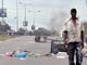 Men walk by tyres set on fire by opposition supporters in Libreville, Gabon(Credit: Reuters)
