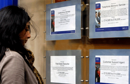 A woman looks at job advertisements in the window of a recruitment agency in Manchester, north-west England(Photo: AFP)