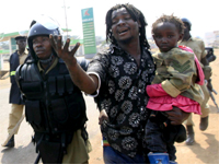 Ugandan police arrest a man carrying a child in a suburb of Kampala on 11 September(Photo: Reuters)