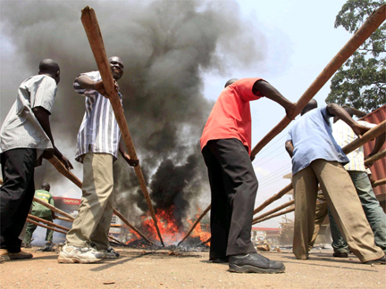 Burning tyres are cleared from the roads in Kampala on 11 September(Photo: Reuters)