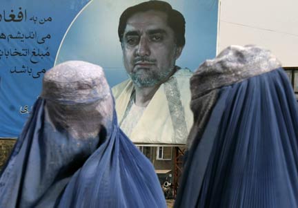 Afghan women walk past a poster of presidential candidate Abdullah Abdullah in Kabul(Photo: Reuters)