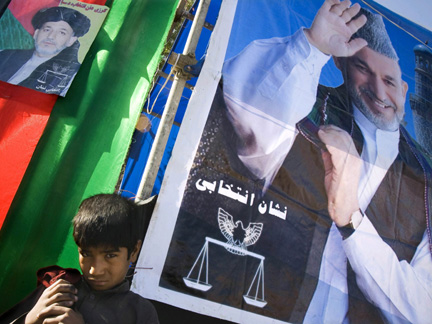 An Afghan boy stands under electoral posters with pictures of Hamid Karzai, who is a candidate for re-election on November 7, in Herat on Saturday
(Photo: Reuters)