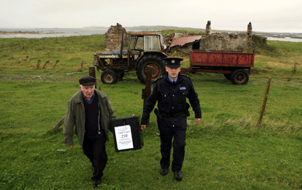Presiding officer Hugh O'Donnell and police officer Barry McCann carry the ballot box used to collect votes on the island of Inishfree, County Donegal on 30 September 2009(Photo: Reuters)