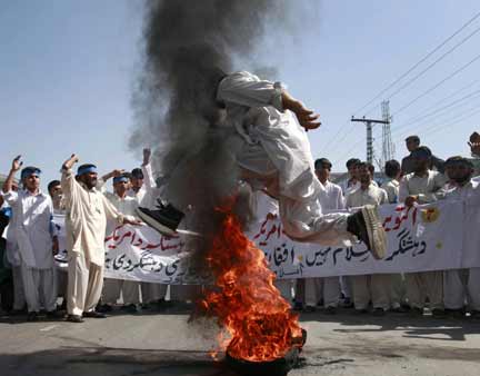 A demonstrator jumps over burning tyres during an anti-American rally in Peshawar organised by the Islamic political party Jamaat-e-Islami (Photo: Reuters)