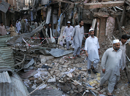 Men return to collect their belongings from their destroyed markets in Peshawar, 29 October 2009(Photo: Reuters)