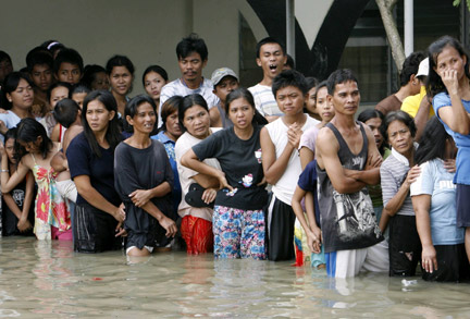 Residents in Pateros, east of the capital Manila, stand in floodwaters brought about by Typhoon Ketsana on 30 September 2009(Photos: Reuters)