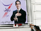 A man puts up a poster for President Abidine Ben Ali(Photo: Reuters)