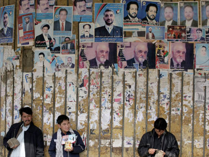Afghan street vendors stand in front of electoral posters in Kabul(Photo: Reuters)