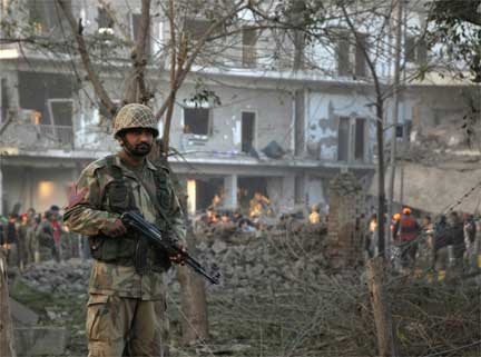 A soldier stands guard in front of the ISI building in Peshawar, the site of a suicide bomb blast on 13 November 2009(Photo: K Parvez/Reuters)