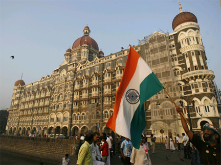 A man walks with the Indian national flag Thursday in front of the Taj Mahal hotel(Photo: Reuters)