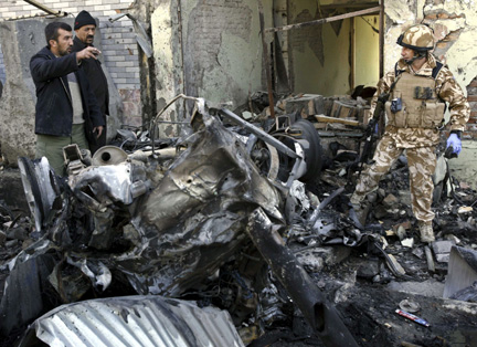 In Kabul, Afghan forces inspect the side of a bomb blast,15 December 2009(Photo: reuters)