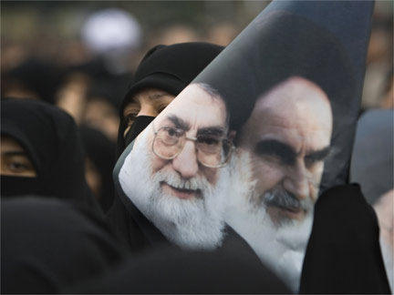 A government supporter holds a poster with images of Iran's leaders during a protest in Tehran(Photo: Reuters)
