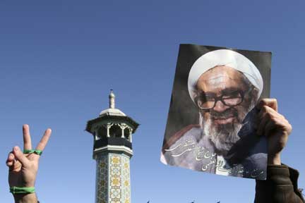 An opposition supporter holds up a picture of Montazeri (Photo: Reuters)