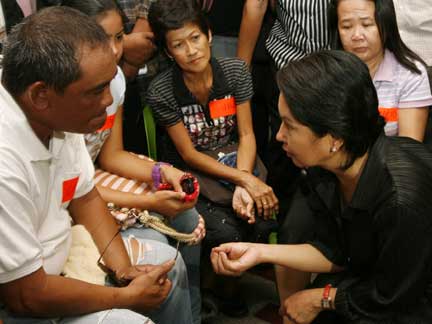 President Gloria Arroyo (R) talks to family members of journalists killed in the Maguindanao massacre(Photo: Reuters)